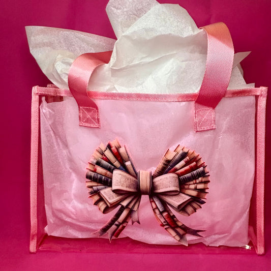 Translucent pink PVC tote with a printed bow made of stacked book spines