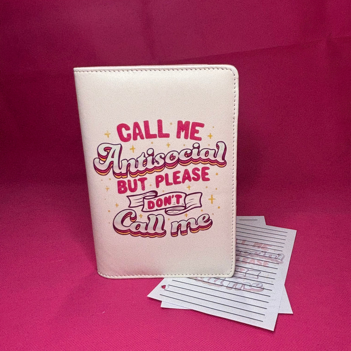 Cream A6 faux leather binder with 'Call Me Antisocial But Please DON'T Call Me' in y2k pink retro drop-shadow lettering with gold stars