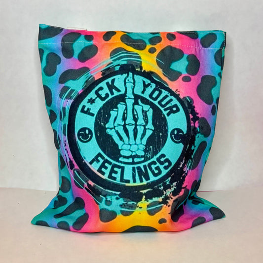 White canvas tote with rainbow leopard print, teal skeleton middle finger, and circle-stamp lettering