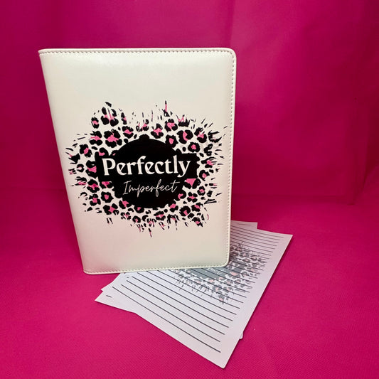Cream A5 faux leather binder with 'Perfectly Imperfect' phrase in a black circle surrounded by pink and black leopard rosettes