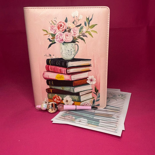 Pink A5 faux leather binder with a painterly stack of leather-bound books topped by a floral teacup with roses