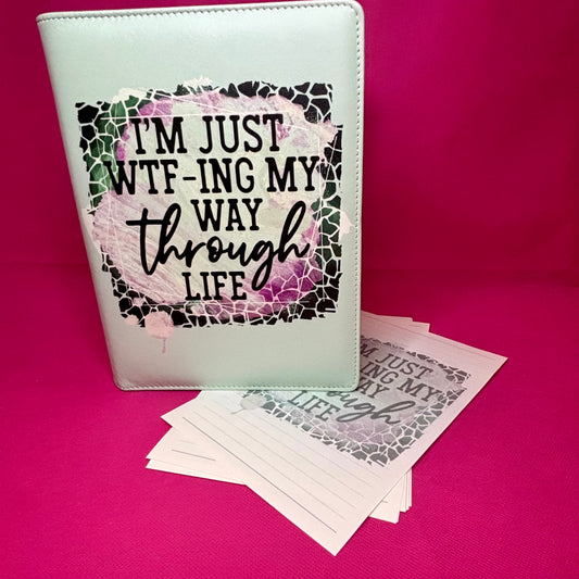 Mint green A5 faux leather binder with 'I'm just WTF-ing my way through life' in a broken-glass frame over a purple-pink watercolor wash