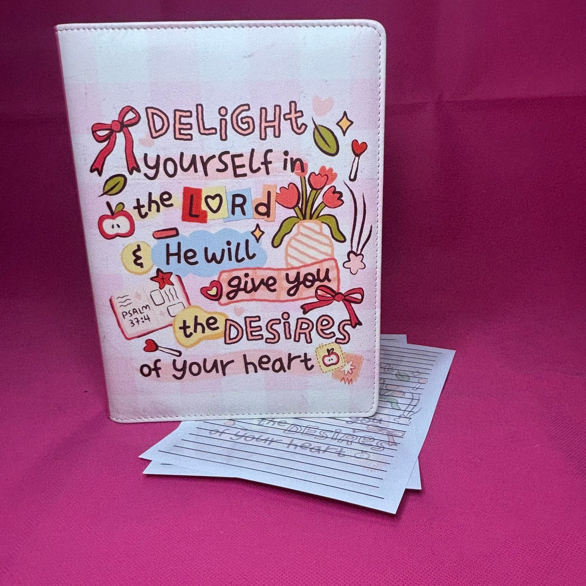 Pink A5 faux leather binder with Psalm 37:4 'Delight yourself in the Lord & He will give you the desires of your heart' in doodle-diary style lettering with tulips and bows