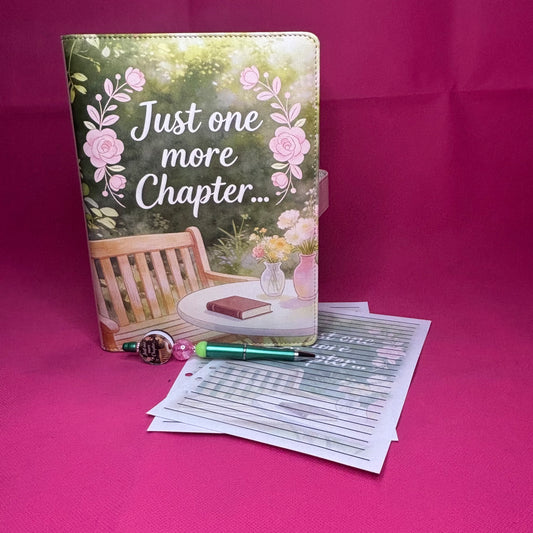 Green cottagecore A5 faux leather binder with a garden bench, pink roses, side table with book, and 'Just one more Chapter...' in white script